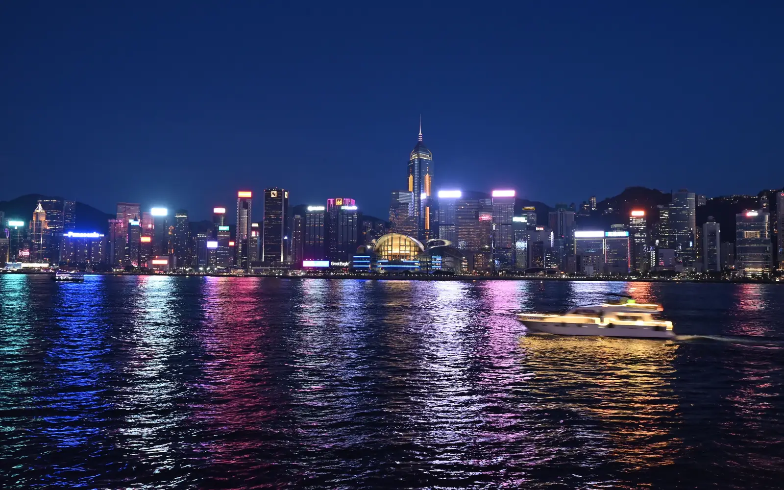The Hong Kong skyline at night, its lights reflected in Victoria Harbour