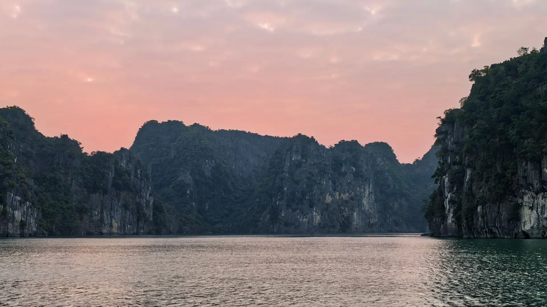 Limestone islands of Ha Long Bay under a pink evening sky, Vietnam